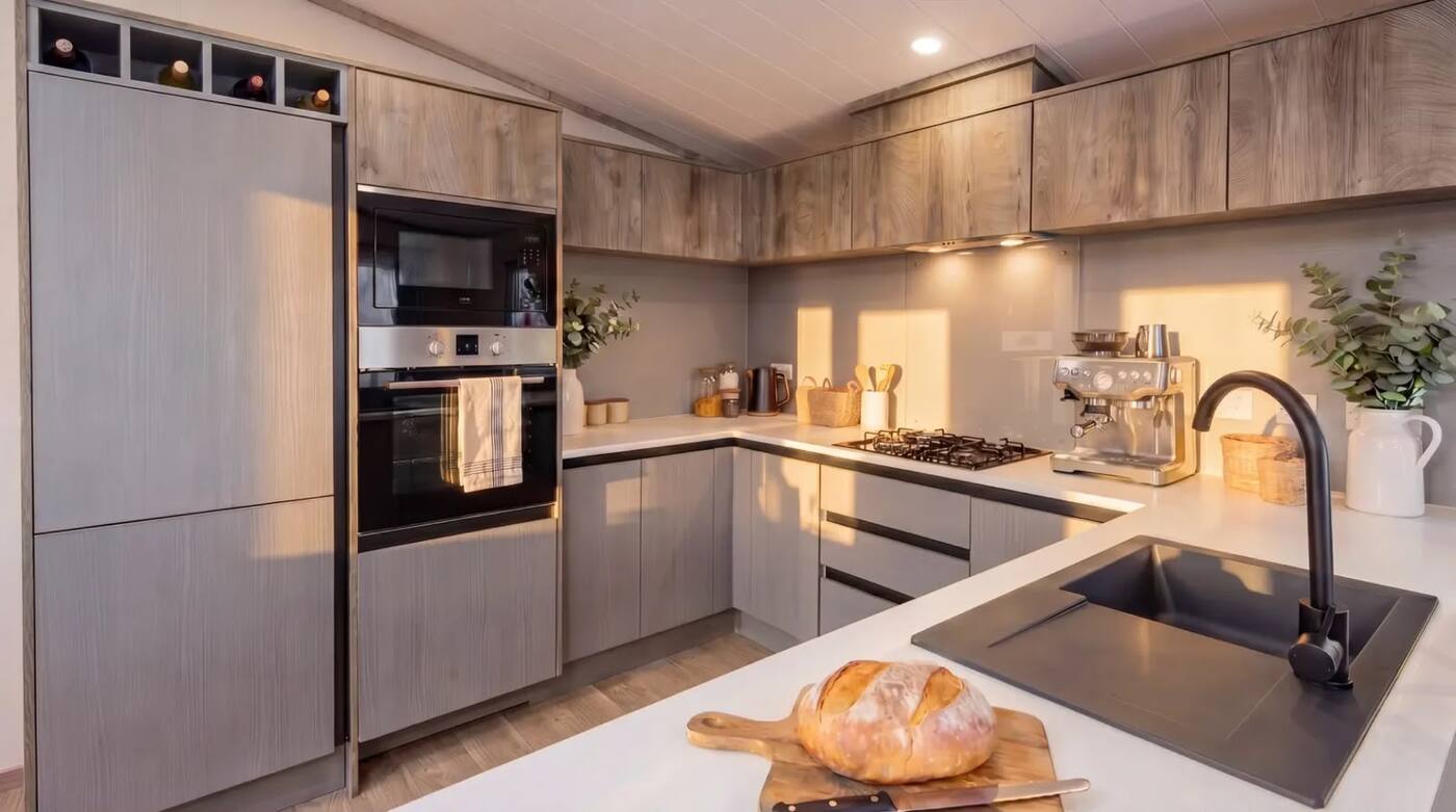 Pale oak handleless kitchen with quartz worktops.
