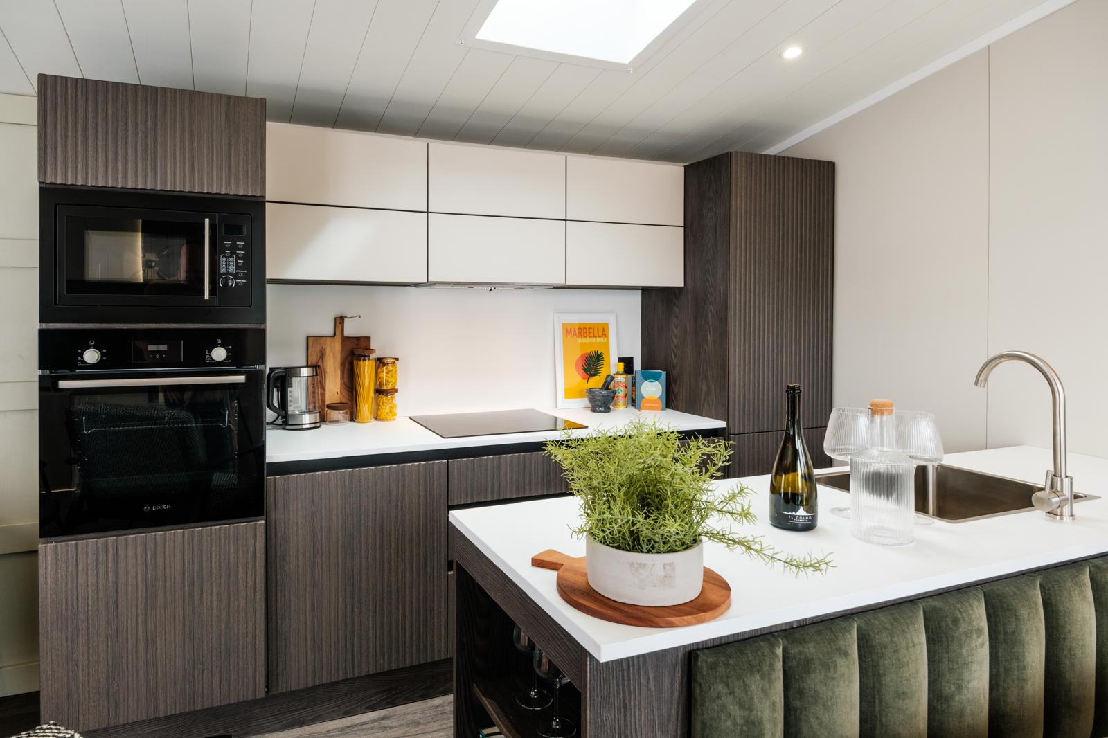 Fitted kitchen with island, oven and skylight.