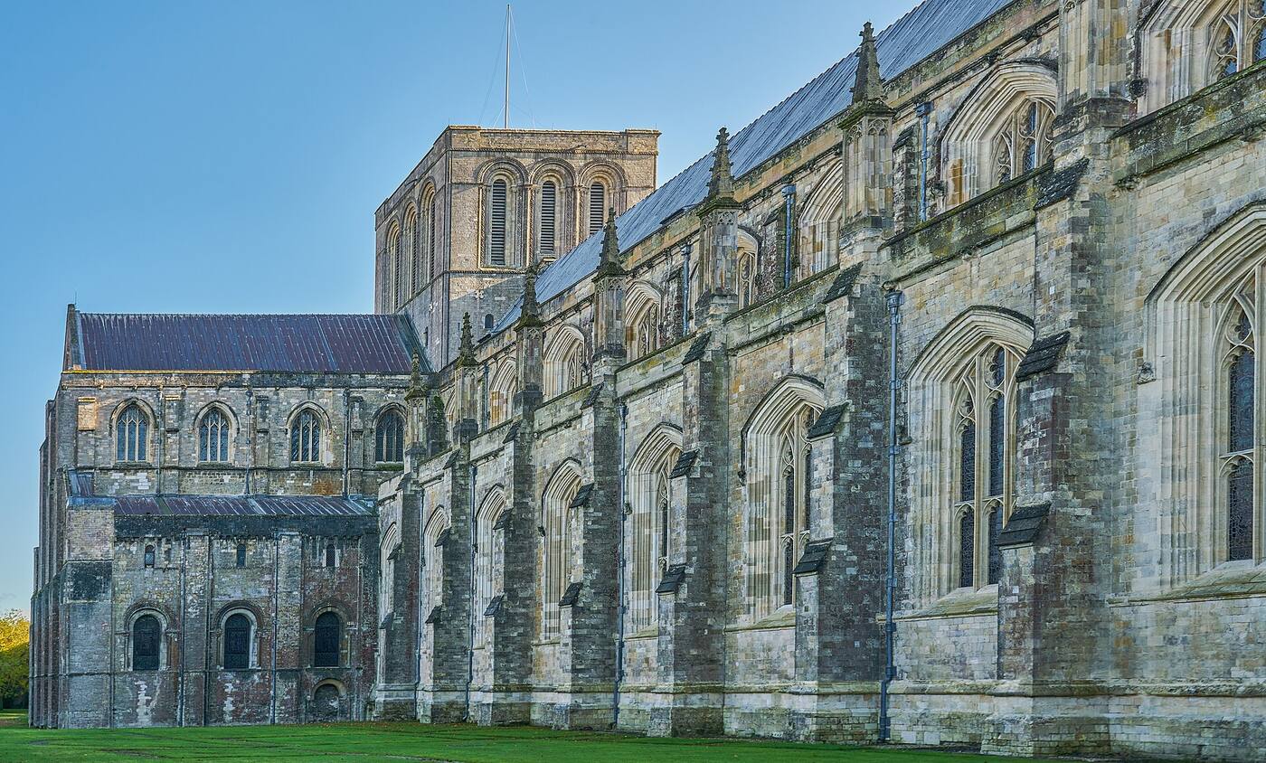 Winchester Cathedral seen across its green in autumn.